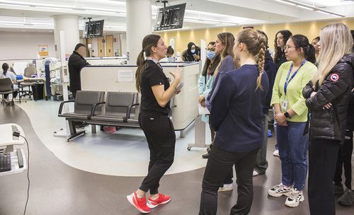 Kayla Feola (au centre), infirmière adjointe intérimaire au Département de l’urgence à l’HGJ, visite la Zone d’évaluation rapide avec un groupe de bénévoles