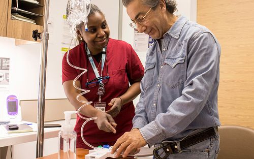 Edgar Iwaz se prépare pour une séance de dialyse péritonéale avec l’aide de l’infirmière Ersie Alexandre.