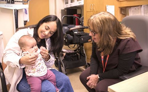 Maria Rivera and her little daughter, Olivia, meet with Clinical Nurse Sabina Figueira.