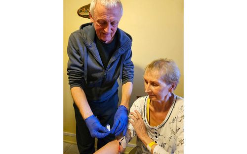 While at home, Krystyna Ludwik receives an intravenous infusion of total parenteral nutrition (TPN) from her husband, Grzegorz Pietrzynski