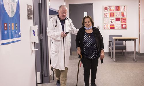 Le Dr Gustavo Duque accompagne une patiente tout en surveillant sa démarche.