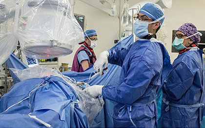 Photo composite du Dr Jeff Golan effectuant une endoscopie vertébrale. En haut, il manipule un outil chirurgical ultramince à travers un tube très étroit en métal inséré dans la colonne vertébrale du patient. En bas, le Dr Golan regarde deux écrans projetant deux radiographies de la colonne vertébrale (gauche et centre) et une vidéo diffusant en temps réel l’effet de son minuscule outil sur le tissu rachidien.